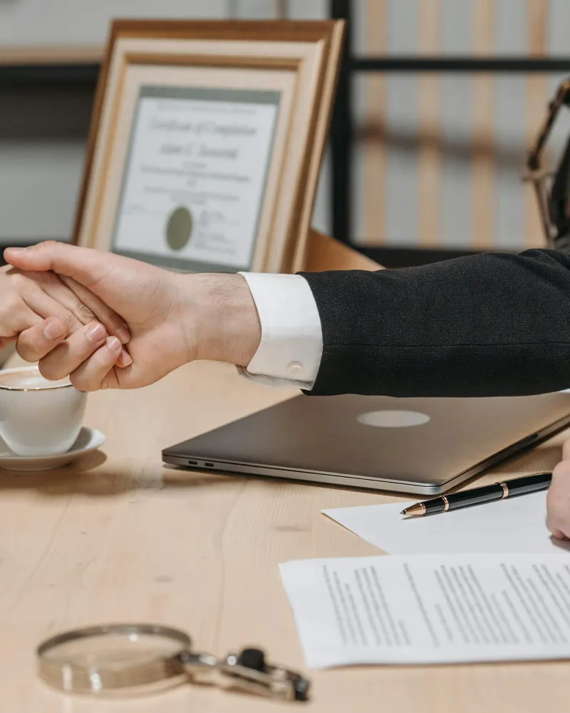 Stretta di mano professionale sopra un contratto su scrivania - concordato minore con accordo tra creditori e imprenditore